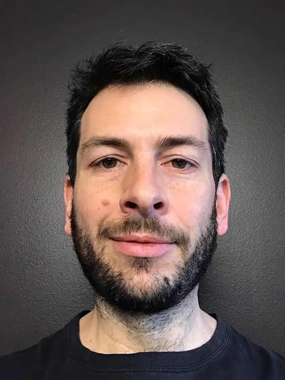 Two photos of a masculine face. The first shows him without glasses and a beard, with the photo taken from below, emphasizing his jaw size. In the second, he is wearing glasses, sporting short stubble, and the photo is taken from above, causing his jaw to appear smaller.