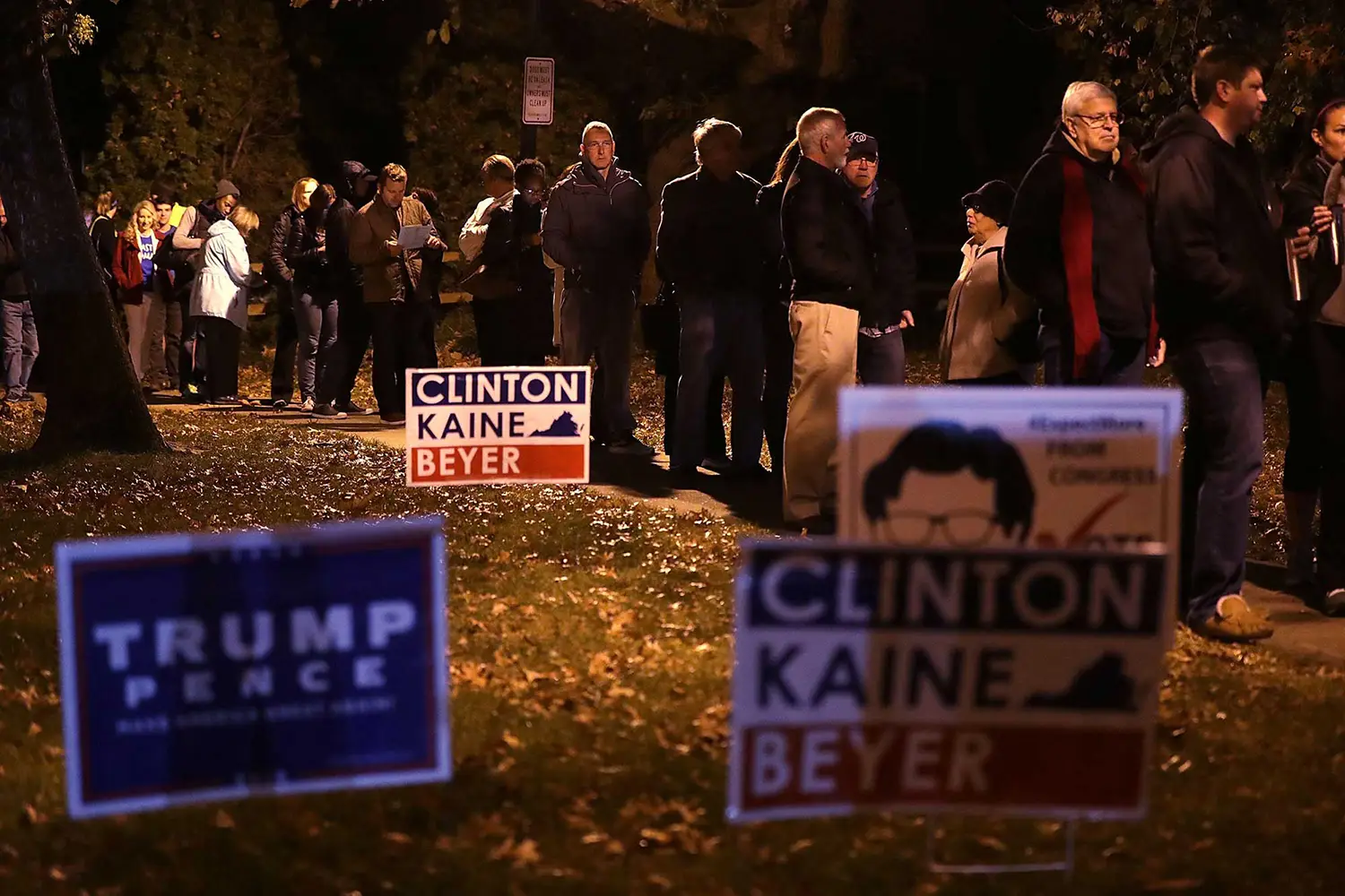 A line of voters standing behind Hilary Clinton and Donald Trump placards. A line of voters standing behind Hilary Clinton and Donald Trump placards.